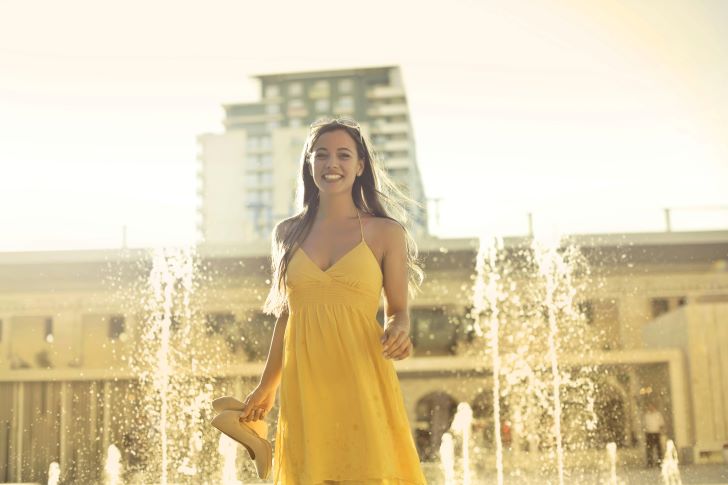 Woman Wears Yellow Dress Stands Near Water Fountain in Tigne Point, Sliema